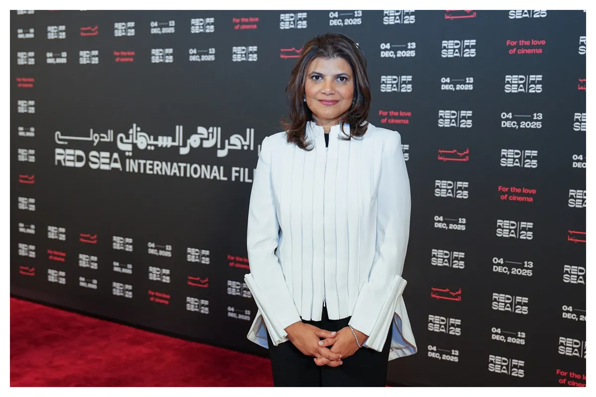 A professional-looking woman smiling brightly at a film festival event.