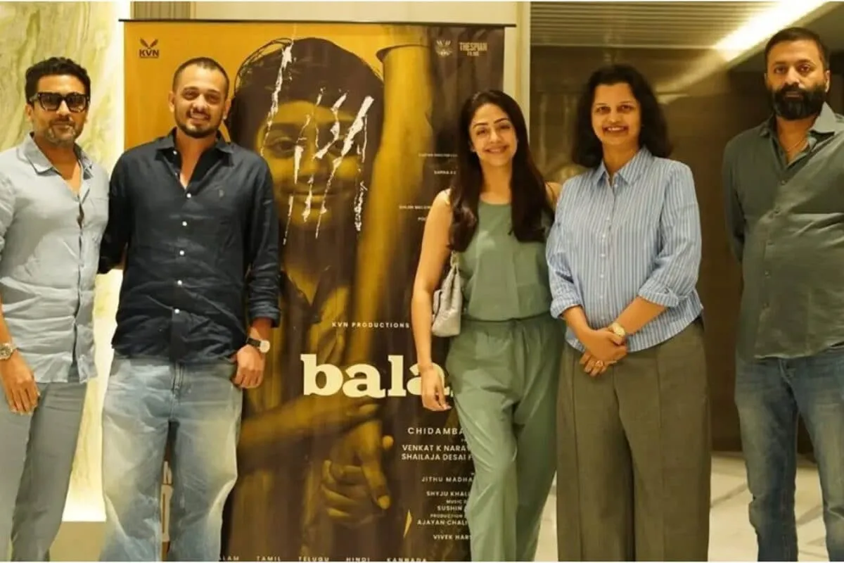Actor Suriya smiling, looking appreciative, with text about 'Balan the Boy' on a phone screen.