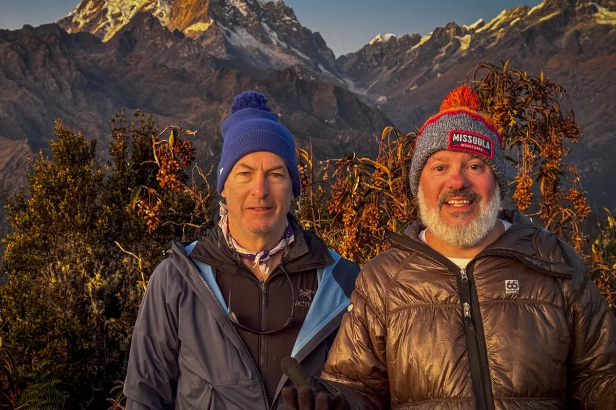 Bob Odenkirk and David Cross smiling and looking mischievous, perhaps on a mountain trail.