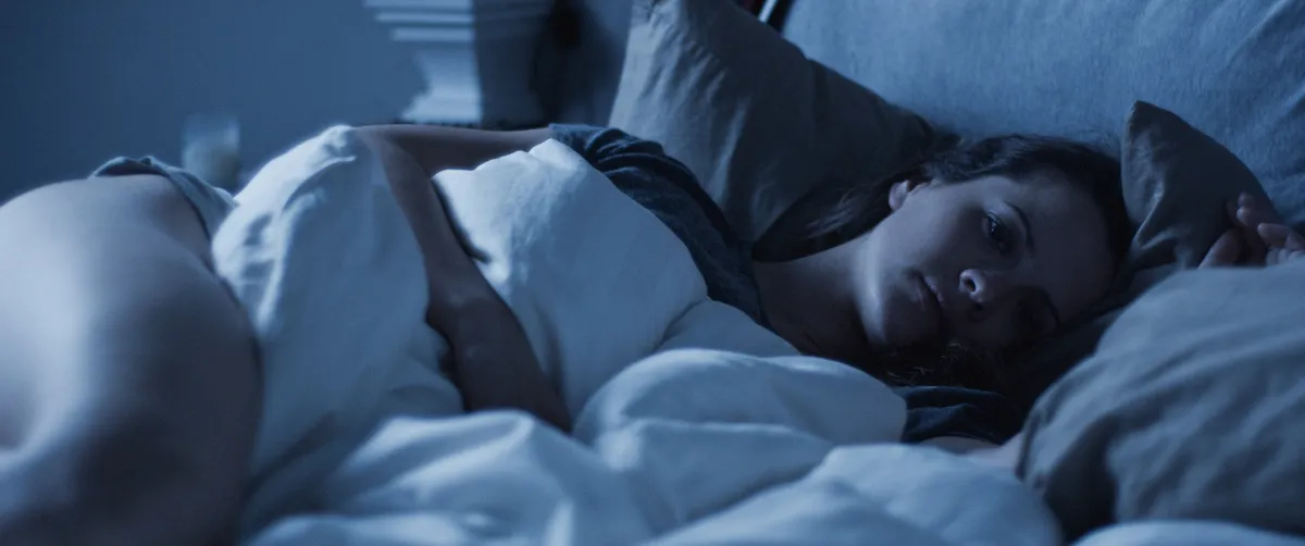 A still image from the short film 'Alone Time' showing a dimly lit room.