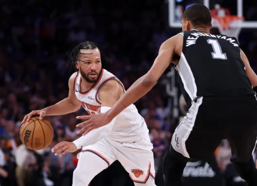 Knicks players celebrating on the basketball court under bright lights