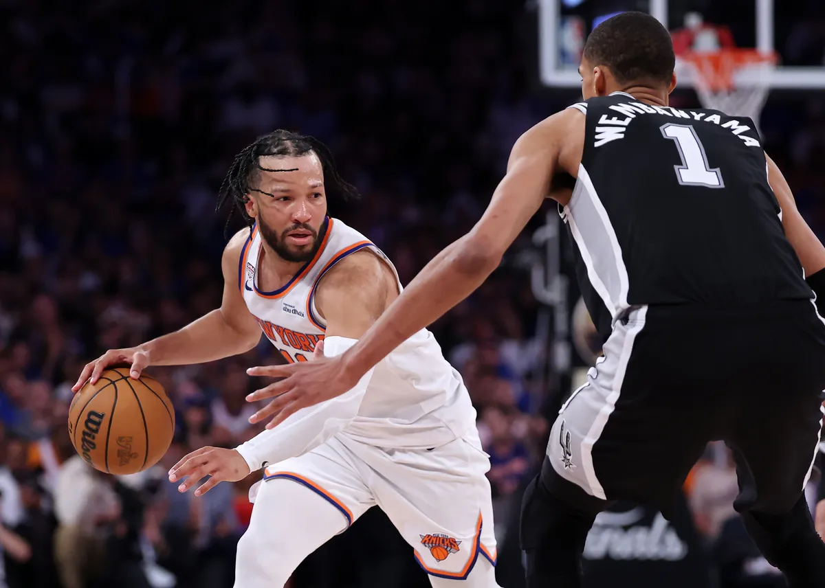Knicks players celebrating on the basketball court under bright lights