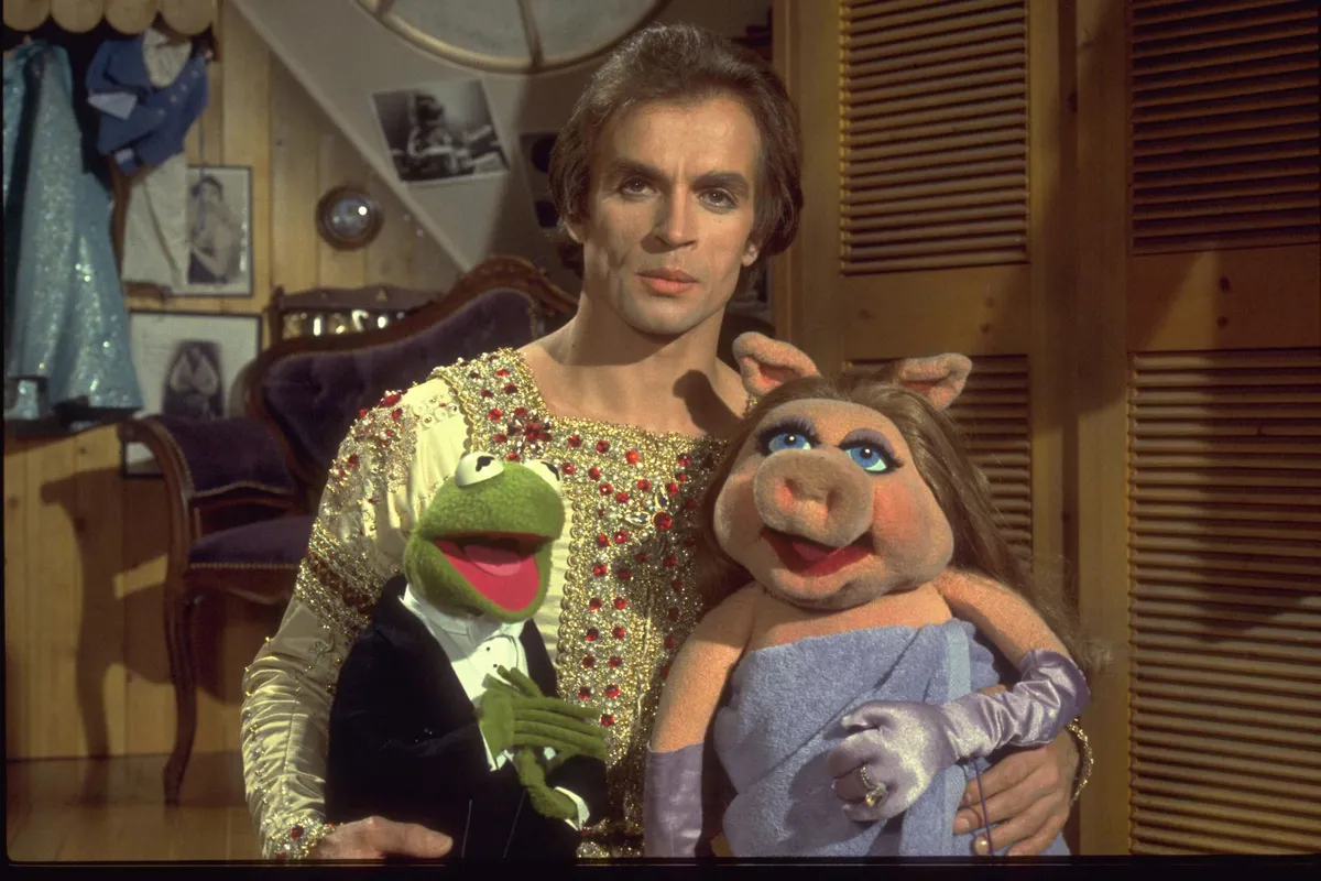Kermit the Frog and Miss Piggy sharing a chaotic stage with a human celebrity guest.
