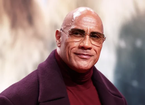 Dwayne 'The Rock' Johnson looking thoughtful and serious, with a blurred, slightly dramatic blue and red visual style in the background.