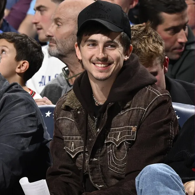 Timothée Chalamet looking stylish and tired at a basketball game