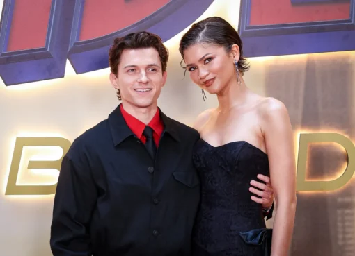 Tom Holland and Zendaya smiling and laughing together at an event.