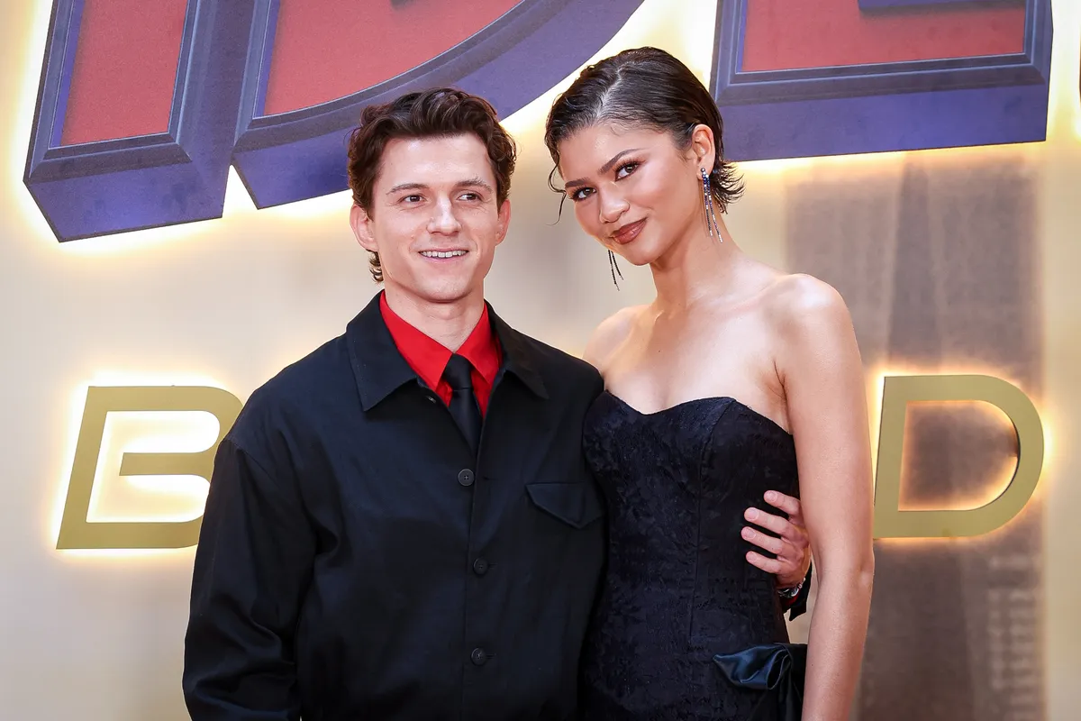 Tom Holland and Zendaya smiling and laughing together at an event.