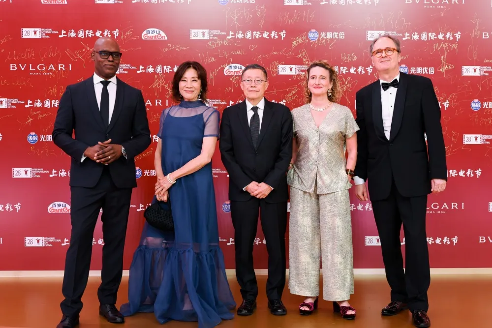 Three film festival directors from Berlin, Toronto, and Hong Kong discussing a panel in Shanghai, possibly smiling and gesturing.