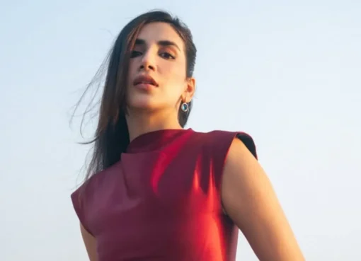 Parul Gulati on a video call, smiling and holding up her hand to show a sparkling diamond ring on her ring finger.