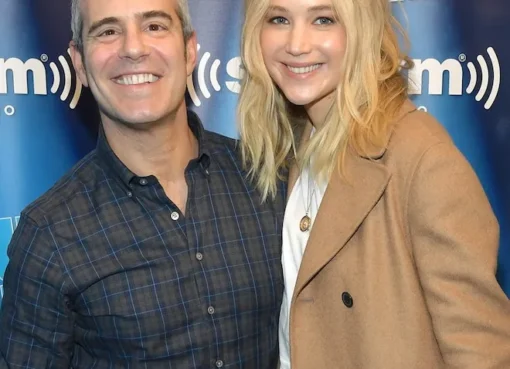 Jennifer Lawrence looking thoughtful, perhaps in a playful detective pose, next to a smiling Andy Cohen.