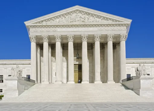 The Supreme Court building with its tall white columns and blue sky