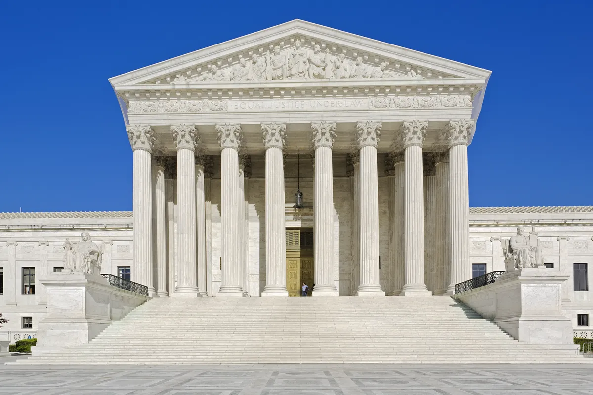 The Supreme Court building with its tall white columns and blue sky