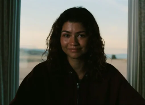 Zendaya looking emotional in a scene with neon lighting