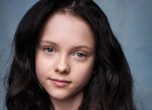 Iona Bell, a young British actress, smiling brightly.