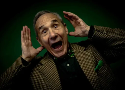 Lloyd Kaufman, veteran filmmaker, holding a vape pen and an energy drink, appearing on screen from Troma Entertainment headquarters.