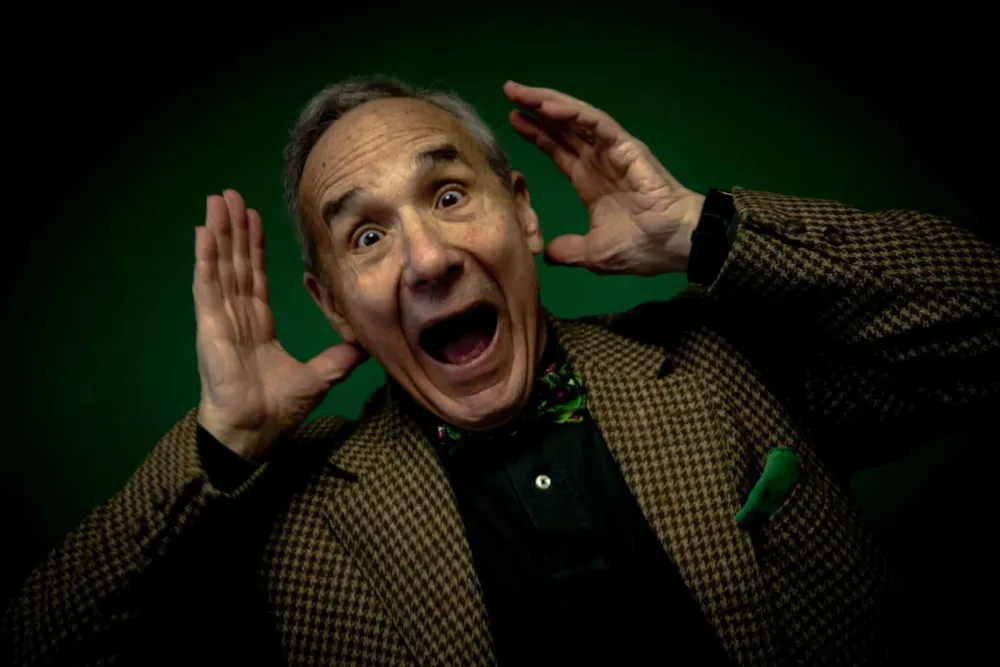 Lloyd Kaufman, veteran filmmaker, holding a vape pen and an energy drink, appearing on screen from Troma Entertainment headquarters.