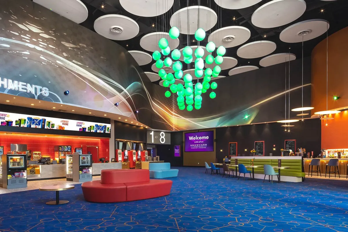 A vibrant, modern movie theater marquee with the Kinepolis logo and 'Showcase Cinemas' next to it, suggesting a new era.