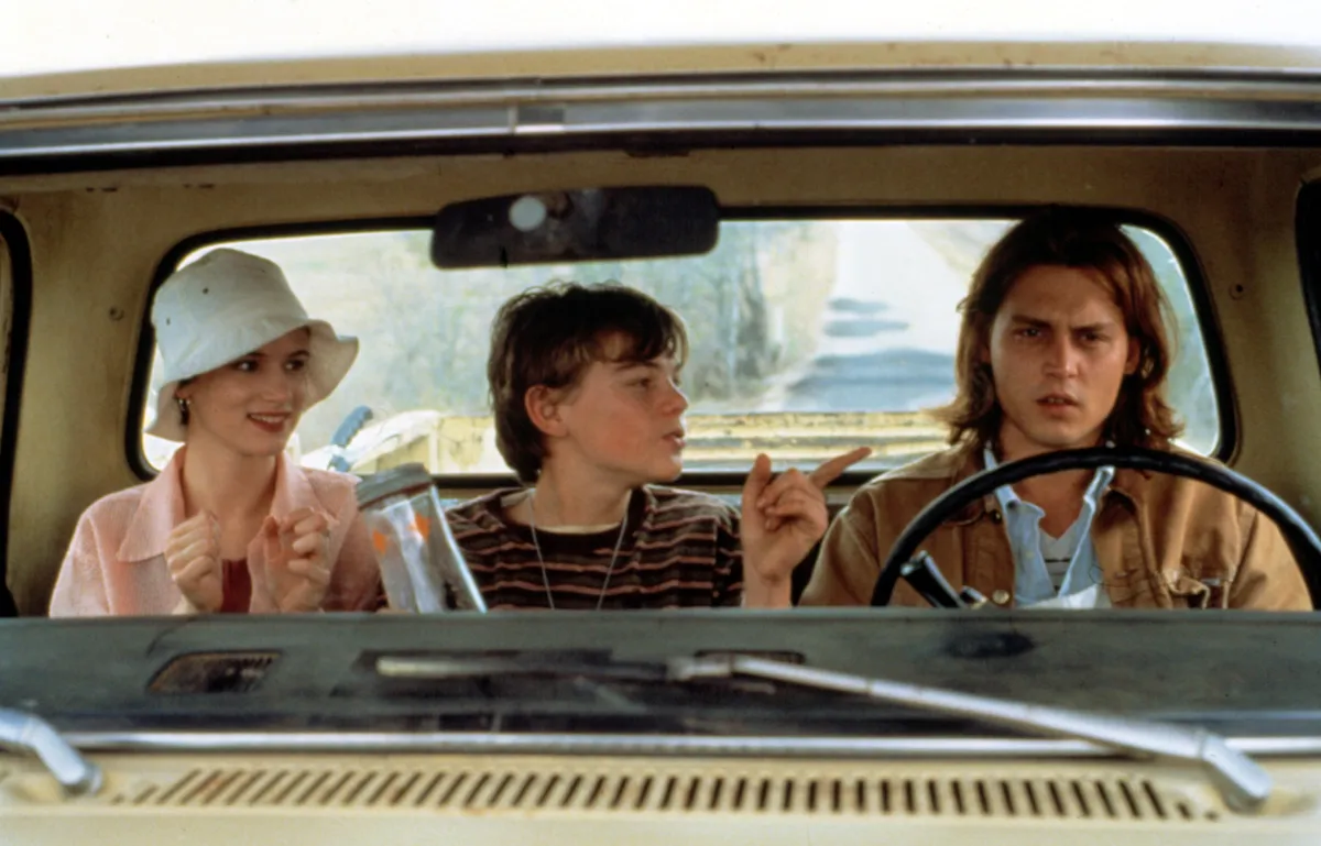 A theater marquee with the words 'What's Eating Gilbert Grape' and 'Musical Premiere' lit up.