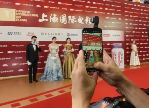 A sleek new Honor Robot Phone with its extendable camera popping out, making its debut on a red carpet.