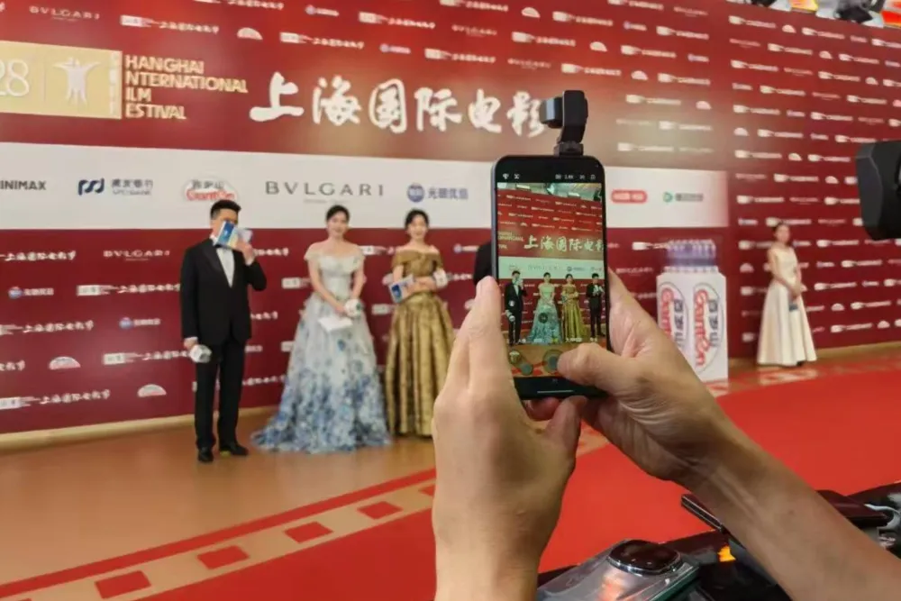 A sleek new Honor Robot Phone with its extendable camera popping out, making its debut on a red carpet.