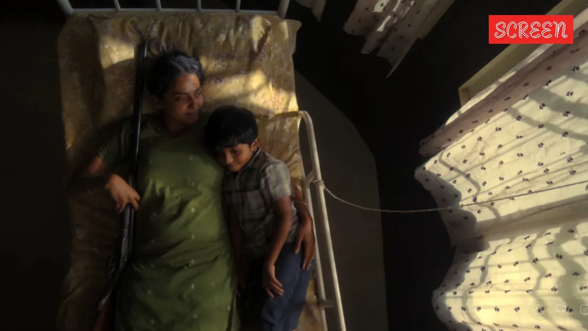 A still from the 'Balan The Boy' trailer showing a mother holding a gun.