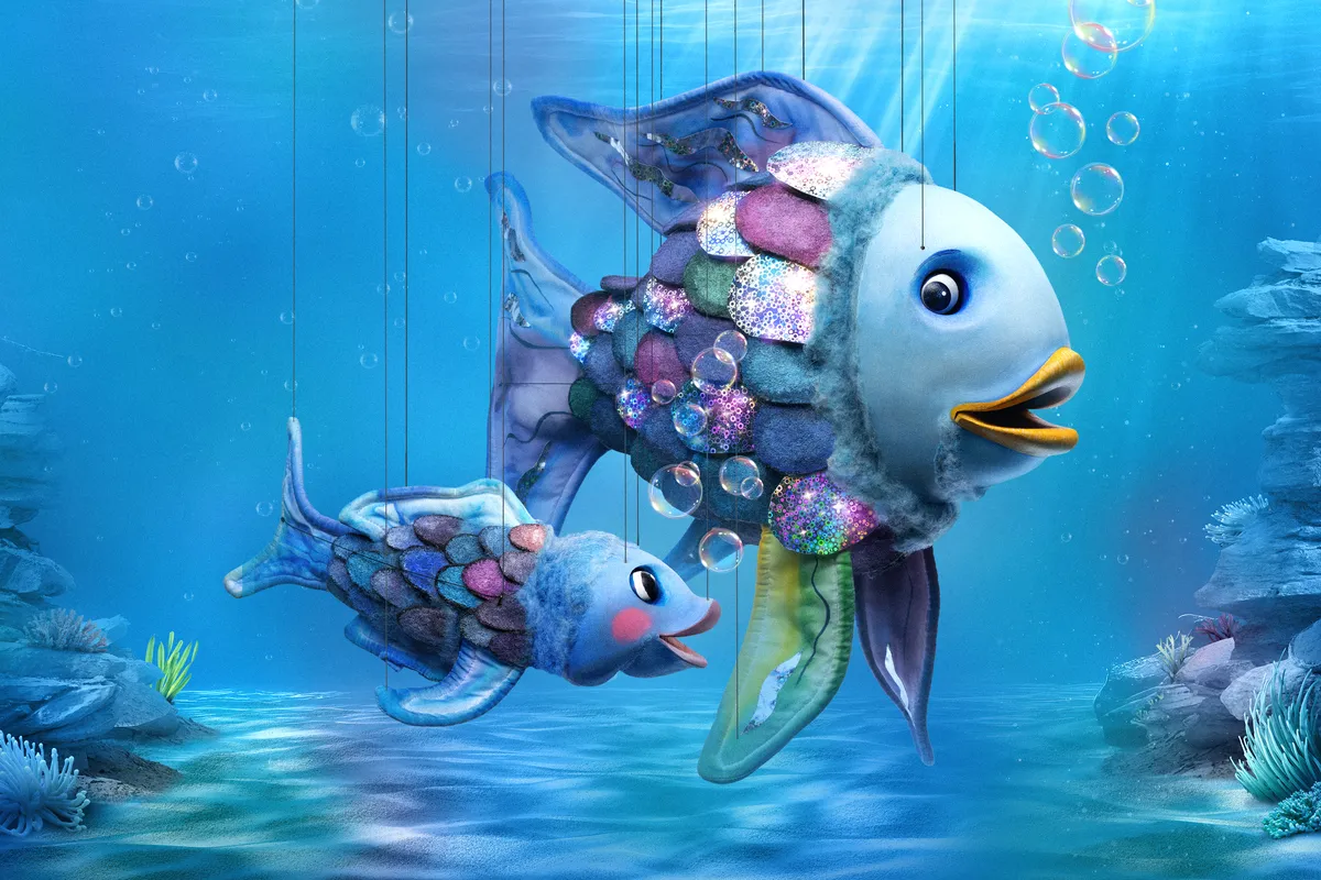 An animated image of The Rainbow Fish with shimmering, colorful scales swimming gracefully in the ocean.