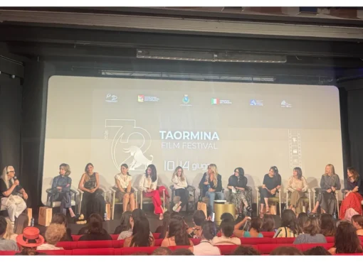 Fernanda Torres speaking animatedly on a panel with other industry professionals.