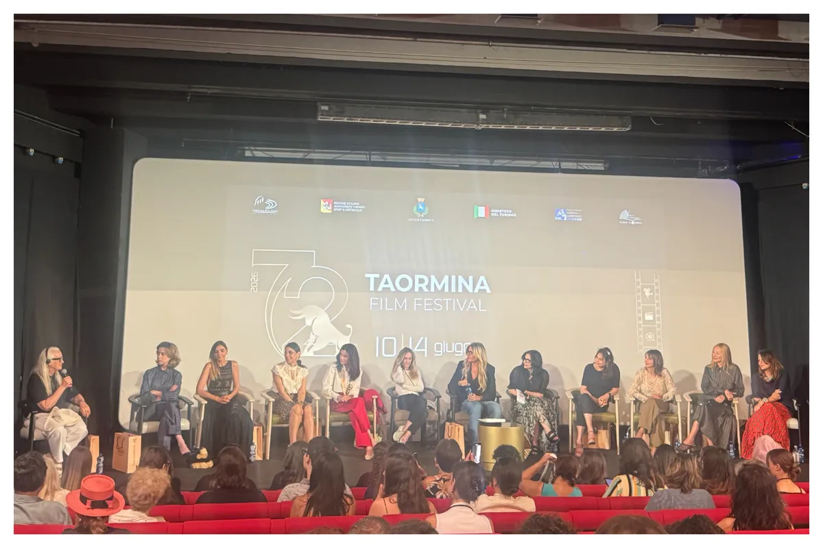 Fernanda Torres speaking animatedly on a panel with other industry professionals.