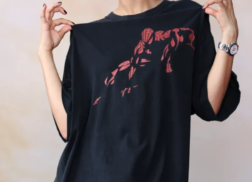Zendaya smiling in an oversized black Spider-Man t-shirt at a fan event.
