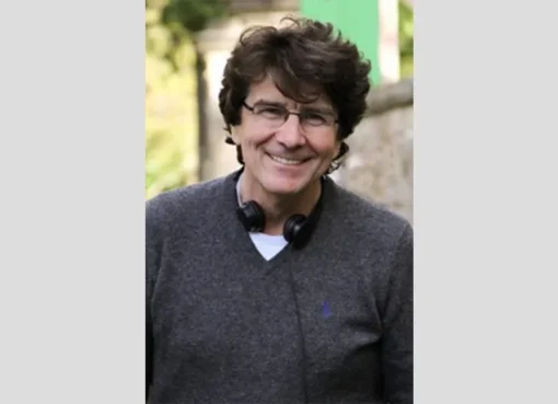 A gentle portrait of John Kirby smiling warmly.