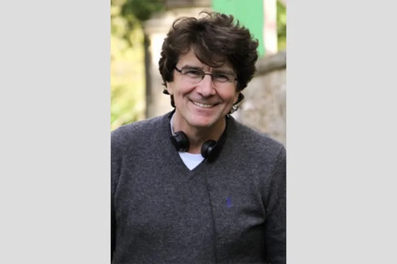A gentle portrait of John Kirby smiling warmly.