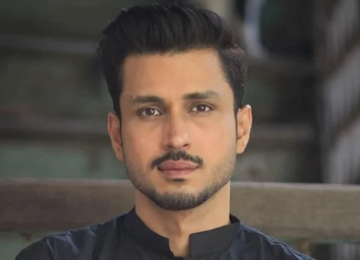 Amol Parashar speaking with a serious expression, a microphone in front of him.