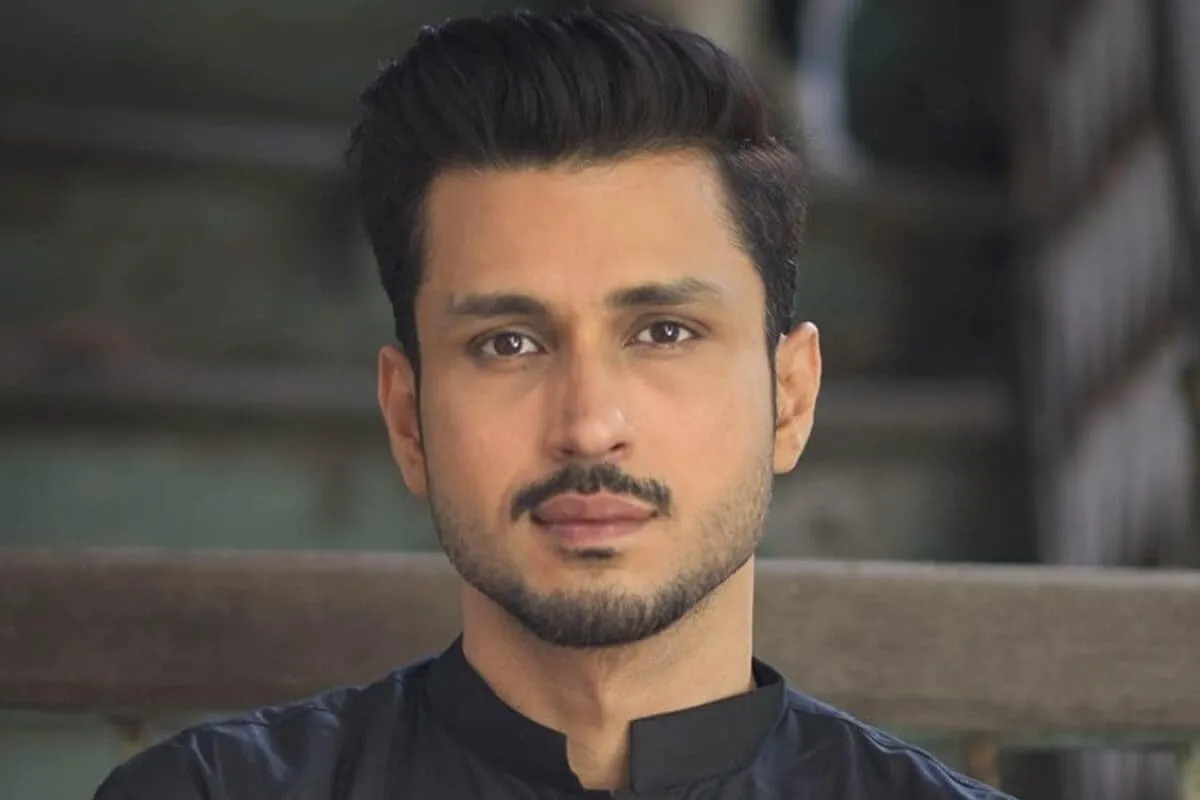 Amol Parashar speaking with a serious expression, a microphone in front of him.