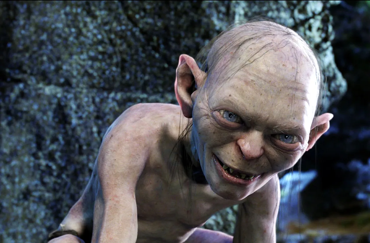 Andy Serkis wearing a gray motion capture suit on the set of The Hunt for Gollum.