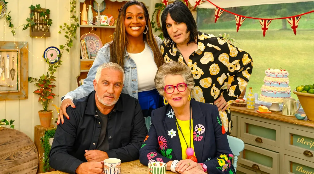A colorful tent from the Great British Bake Off set, surrounded by green grass.