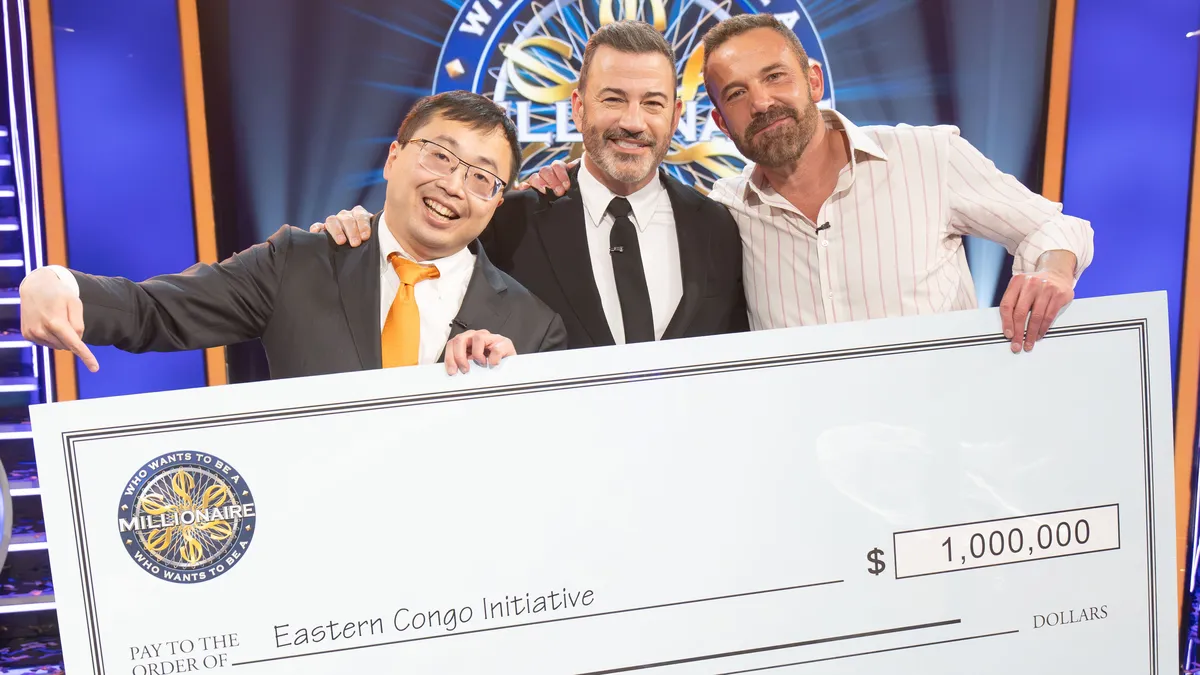 Ben Affleck and Jamie Ding celebrating their win on Who Wants to Be a Millionaire.