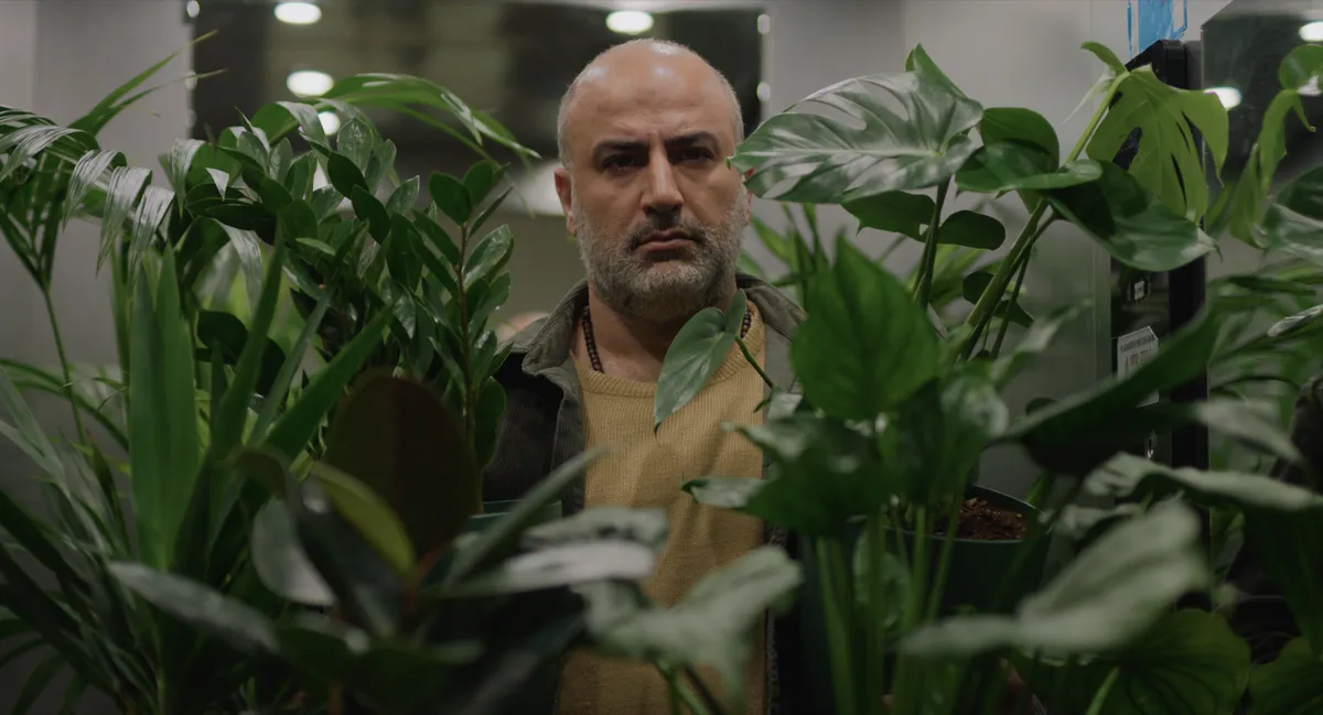 A film still showing a pensive doctor in a modern Iranian setting.