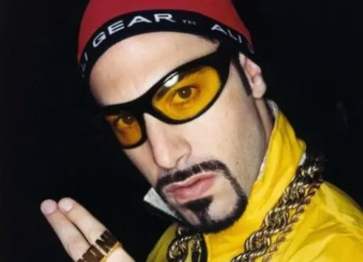 Sacha Baron Cohen as Ali G with his signature yellow tracksuit and sunglasses.