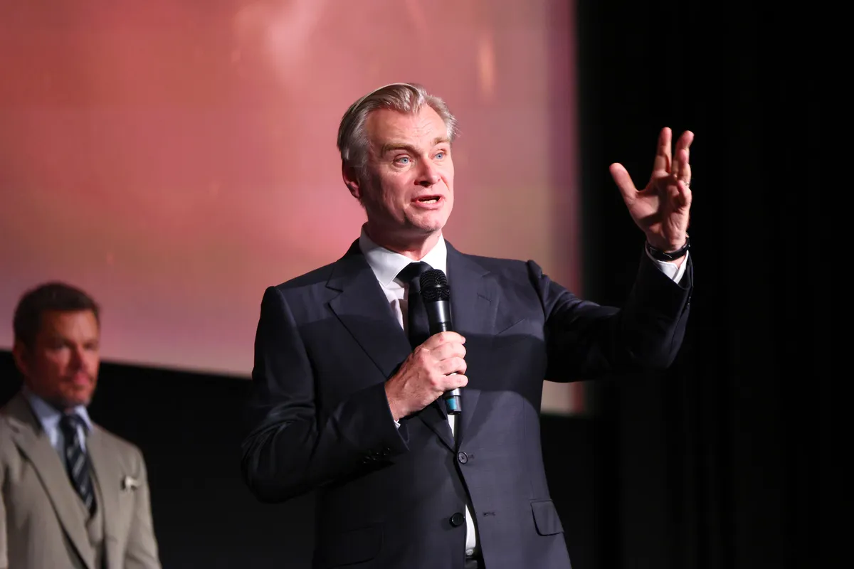 Christopher Nolan speaking at a film premiere, expressing a heartfelt dedication.