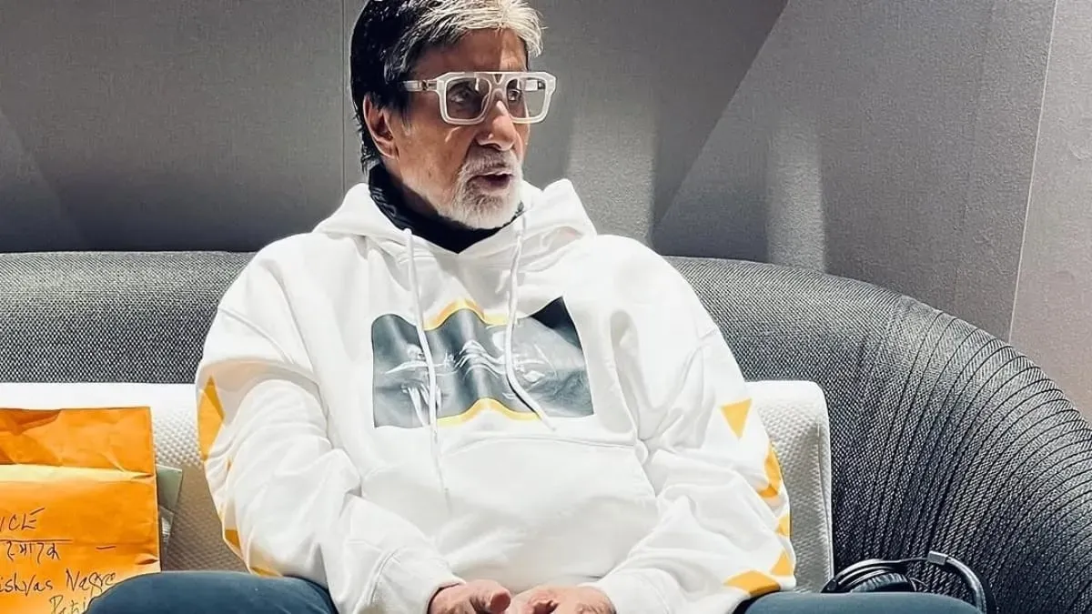 Amitabh Bachchan looking thoughtful and serious in a dark suit.