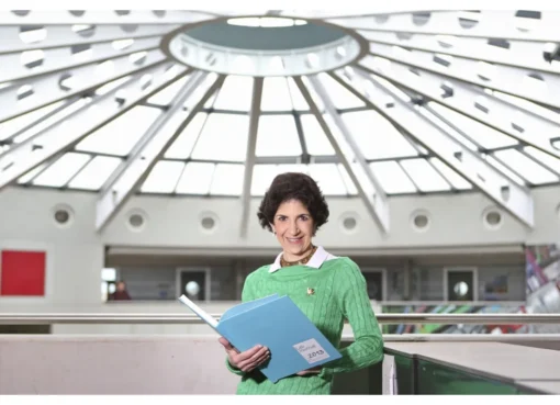 Close-up photo of Italian physicist Fabiola Gianotti smiling thoughtfully.