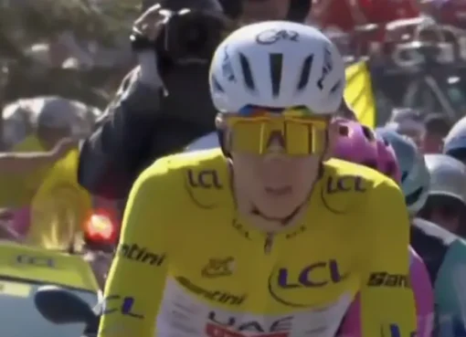 Tadej Pogacar in a yellow cycling jersey, smiling and celebrating his victory at the Tour de France.