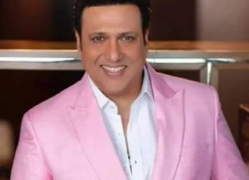 Actor Govinda smiling, gesturing excitedly with a vibrant background.