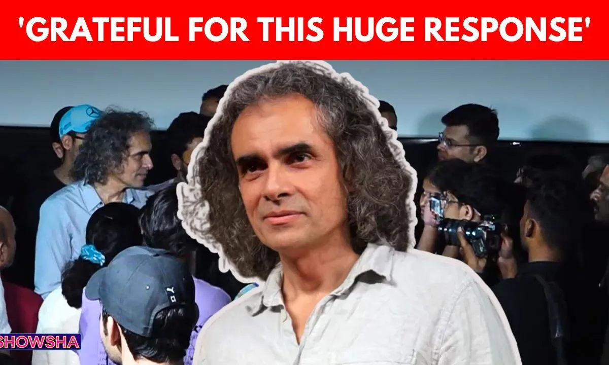Imtiaz Ali smiling and interacting with happy fans inside a movie theatre.