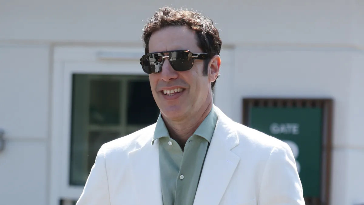 Sacha Baron Cohen dressed as Ali G in a bright yellow tracksuit at Wimbledon.