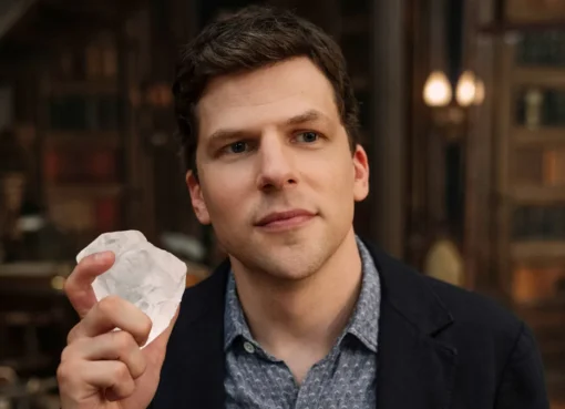 Jesse Eisenberg smiling and looking thoughtful.