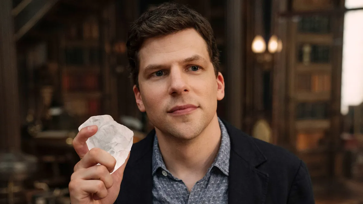 Jesse Eisenberg smiling and looking thoughtful.