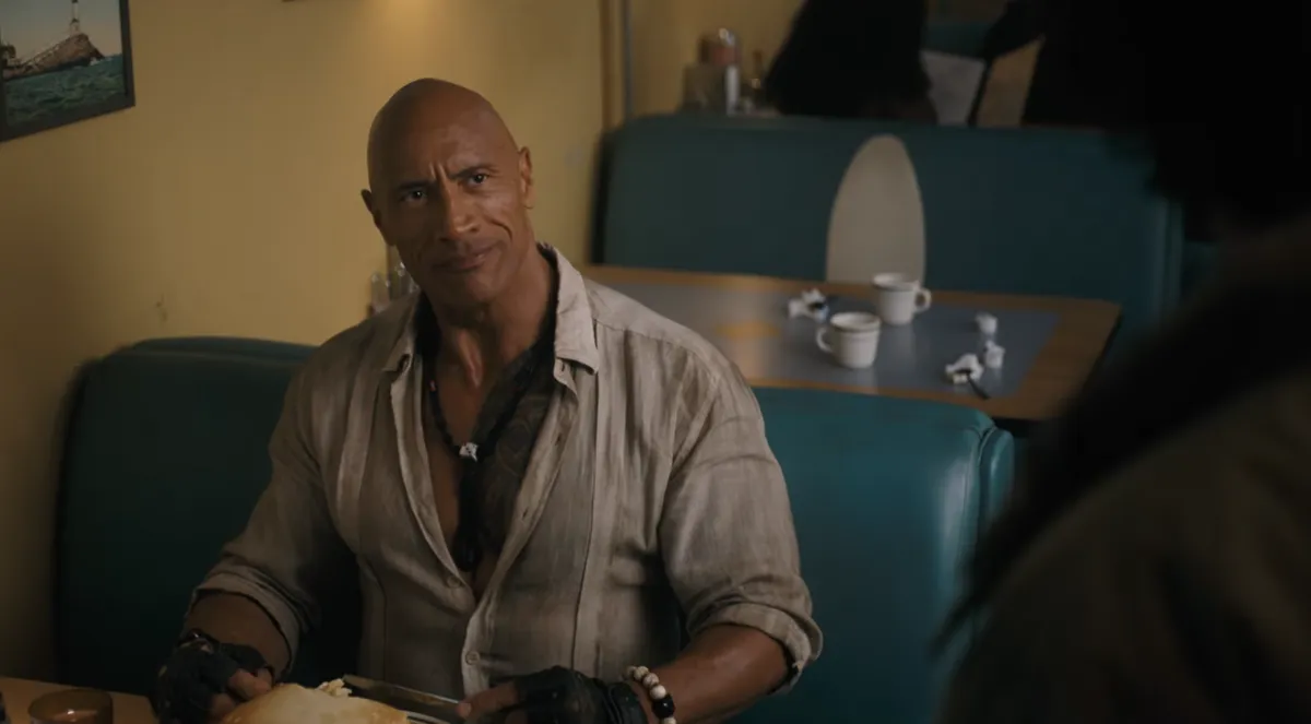 The videogame characters from Jumanji standing in a regular kitchen.