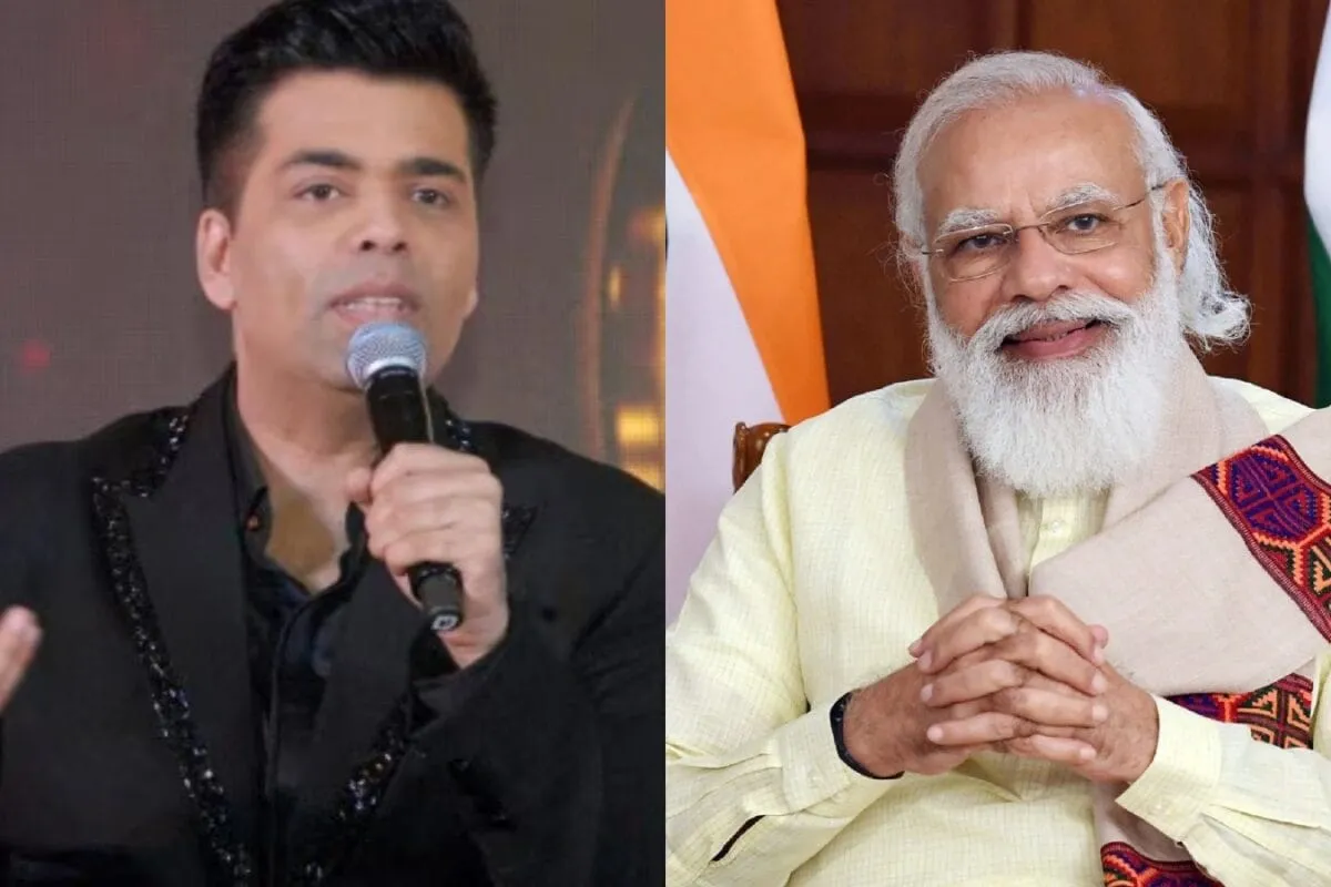 Karan Johar smiling widely, looking happy and honored.