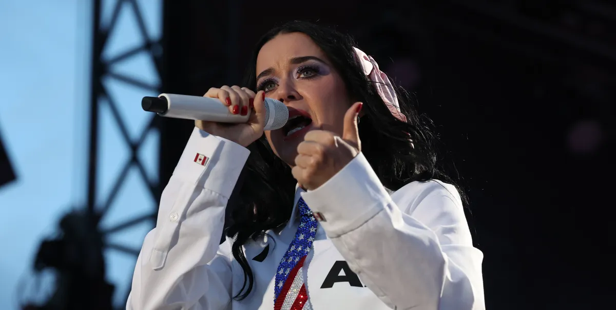 Katy Perry performing on stage with fireworks in the background.